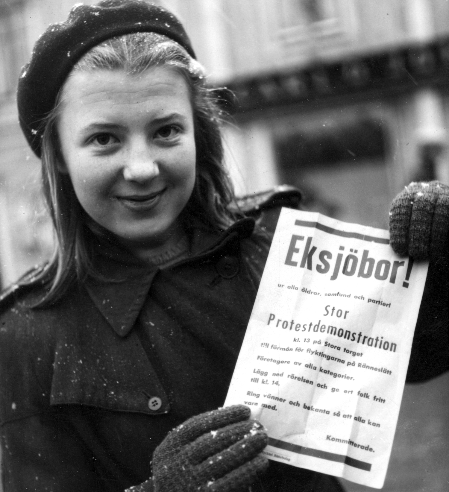 Ung flicka med ett flygblad som kallar till protestdemonstration.