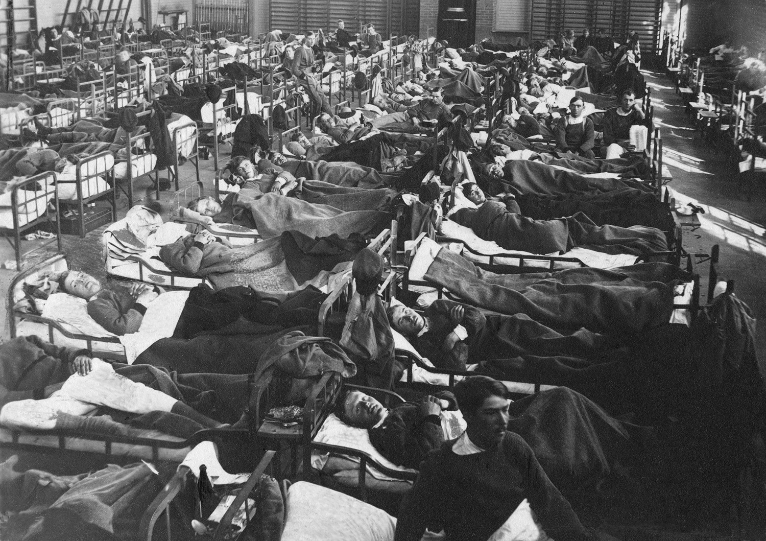 Patienter ligger i sängar i långa rader, svartvit bild